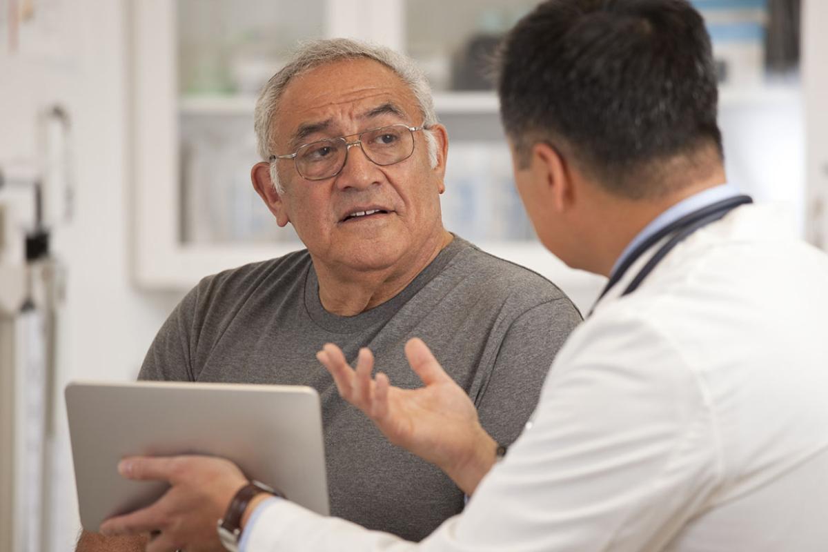 Physician speaking with and gesturing toward patient 