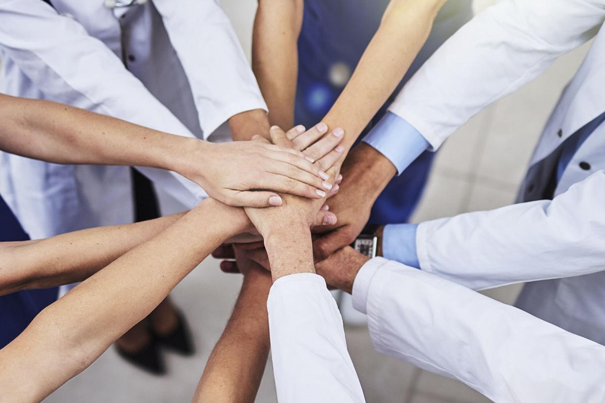 A team of doctors joining their hands together